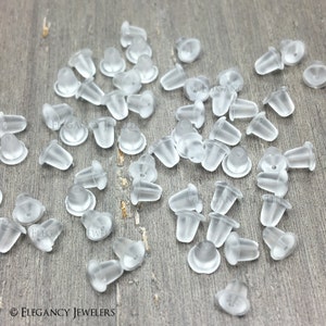 May include: A large quantity of clear plastic earring backs. The backs are small and have a rounded top and a flat bottom.