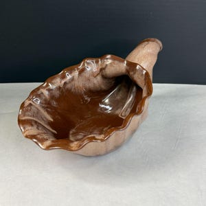 May include: A set of three ceramic mugs with a speckled, matte finish. The mugs are in shades of cream, light gray, and dark gray. Each mug has a simple, minimalist design, perfect for coffee or tea.