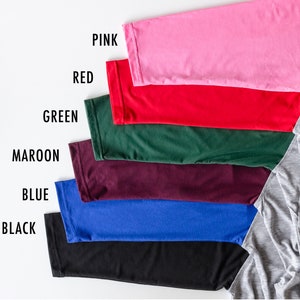 May include: A set of seven fabric swatches in various colors, including pink, red, green, maroon, blue, black, and gray. The swatches are arranged in a row from top to bottom, with the gray swatch at the bottom right.