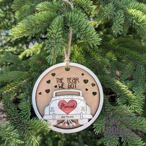 Op de afbeelding: Een ronde houten ornament met een witte auto en de tekst "The Year We Got Married Aug. 7th, 2021". De auto heeft een rood hart met het woord "Married" erin.