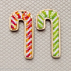 May include: Two wooden candy cane ornaments, one with a red, orange, and white plaid pattern and the other with a green and white plaid pattern.