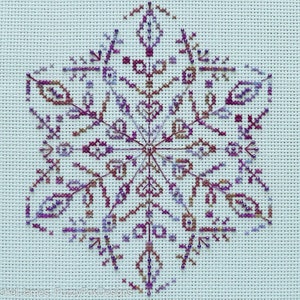 May include: A purple, brown and white snowflake cross-stitch pattern on white Aida cloth.