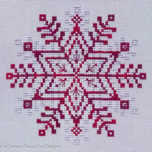May include: A red and white snowflake cross-stitch pattern on white fabric.