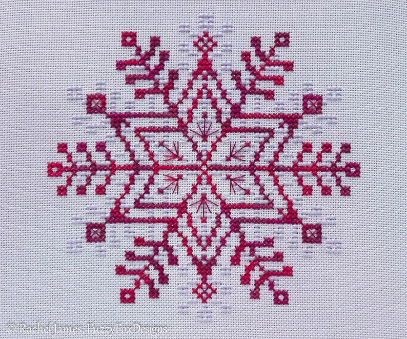 May include: A red and white snowflake cross-stitch pattern on white fabric.