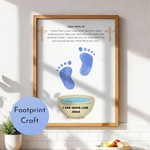 May include: A framed print with a light brown wooden frame. The print features blue footprints, a bowl of water, and text from John 13:14-15. The words "Footprint Craft" are in a blue circle, and "I CAN SERVE LIKE JESUS" is on the bowl.