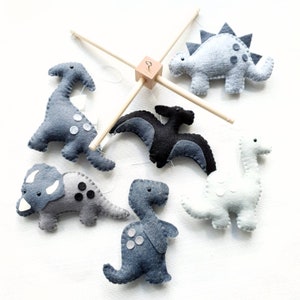 Monochrome dinosaur mobile on a wooden frame. Black and grey dinos