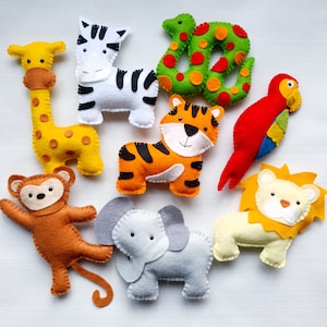 May include: A set of ten felt animal toys, including a giraffe, zebra, tiger, monkey, elephant, lion, parrot, and snake. The toys are all brightly coloured and have embroidered details.
