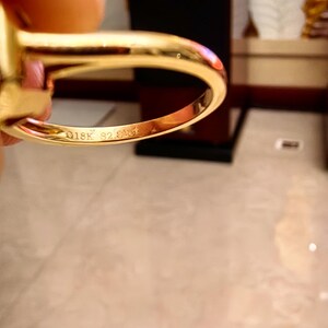 May include: A polished yellow gold ring with a smooth, rounded band. The interior of the band features a clear engraving that reads 18K followed by S2.01ct, indicating the gold purity and the carat weight of the stone set within the ring.