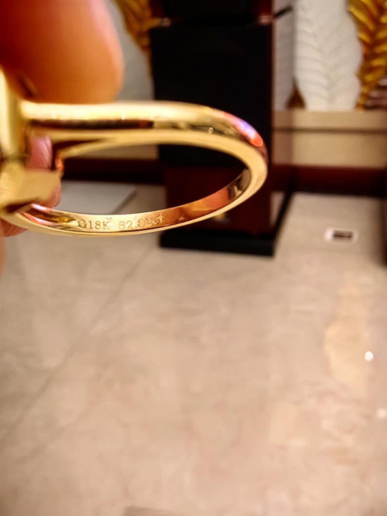 May include: A polished yellow gold ring with a smooth, rounded band. The interior of the band features a clear engraving that reads 18K followed by S2.01ct, indicating the gold purity and the carat weight of the stone set within the ring.