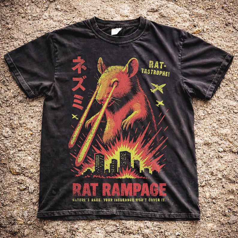 May include: Black t-shirt with a graphic of a rat emitting laser beams, above a city skyline. The text reads "RAT RAMPAGE" and "NATURE'S RAGE. YOUR INSURANCE WON'T COVER IT."