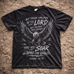 Puede incluir: Camiseta negra con un diseño de águila con las alas extendidas y el texto: "Pero los que esperan a Jehová tendrán nuevas fuerzas; levantarán alas como las águilas; Isaías 40:31."