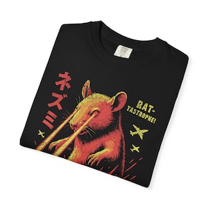 May include: Black t-shirt with a graphic of a rat emitting laser beams from its eyes. The design includes Japanese text and the phrase "RAT-TASTROPHE!" in yellow and red.