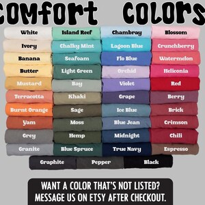 May include: A color chart displaying a variety of fabric colors, including white, blue, pink, and green. The text "Comfort Colors" is at the top, with a call to action at the bottom: "Want a color that's not listed? Message us on Etsy after checkout."