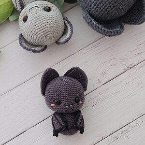 Puede incluir: Tres animales de peluche tejidos a crochet: un conejito gris, un murci&eacute;lago gris con alas negras y un b&uacute;ho gris. Los animales tienen ojos negros y mejillas rosadas.