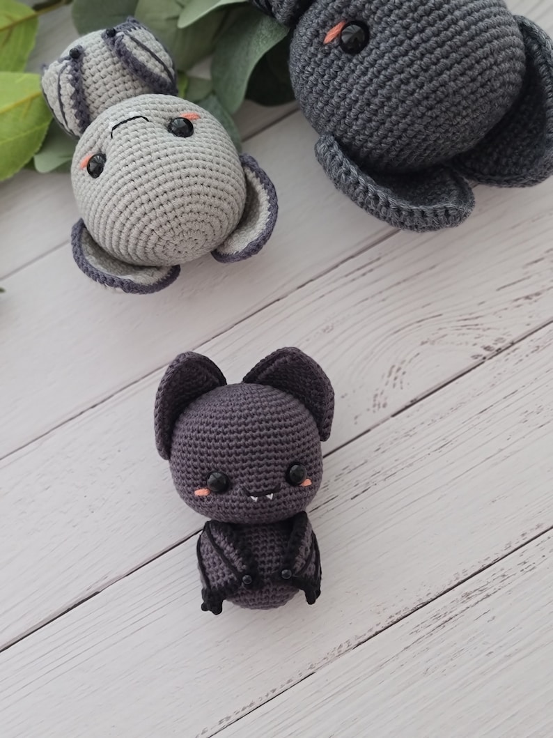 Puede incluir: Tres animales de peluche tejidos a crochet: un conejito gris, un murci&eacute;lago gris con alas negras y un b&uacute;ho gris. Los animales tienen ojos negros y mejillas rosadas.
