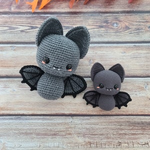 Puede incluir: Dos murci&eacute;lagos de crochet grises con ojos negros y alas. El murci&eacute;lago m&aacute;s grande tiene una sonrisa de dientes y es ligeramente m&aacute;s grande que el m&aacute;s peque&ntilde;o.