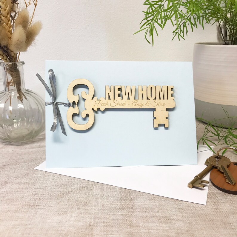 wooden key shape engraved with your special message and names of the new home owners attached to a card as a housewarming keepsake gift