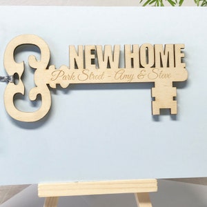 wooden key shape engraved with your special message and names of the new home owners attached to a card as a housewarming keepsake gift