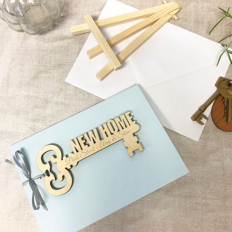 wooden key shape engraved with your special message and names of the new home owners attached to a card as a housewarming keepsake gift