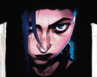 May include: Black t-shirt featuring a graphic print of a woman's face with blue hair and dark eyes. The woman is looking directly at the viewer with a serious expression.