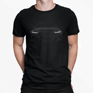 May include: A black t-shirt with a silhouette of a black car on the front. The car has white headlights and a black grille.