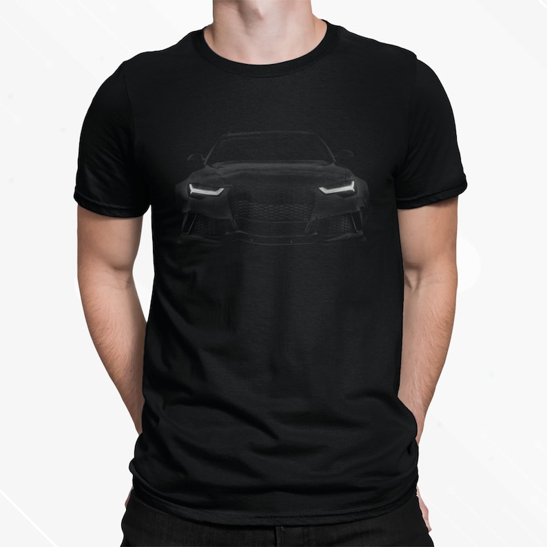 May include: A black t-shirt with a silhouette of a black car on the front. The car has white headlights and a black grille.