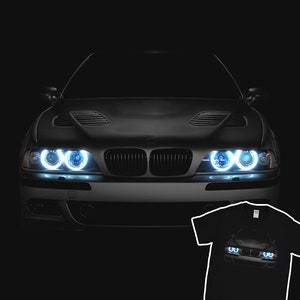May include: A black BMW with bright white headlights. The car is in a dark setting, with only the headlights illuminating the front of the car. The car is a popular model for car enthusiasts.