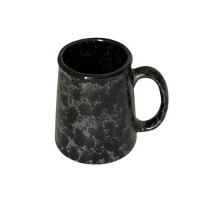 May include: A cylindrical mug featuring a black base color with a mottled, grey marbled pattern throughout the exterior surface. The mug includes a single curved handle on the right side and a smooth, rounded rim at the top opening.