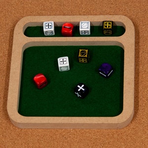 May include: A wooden dice tray with a green felt interior. The tray has a raised section for dice to be rolled into. There are seven dice in the tray, including a red die, a purple die, a black die, and four white dice.