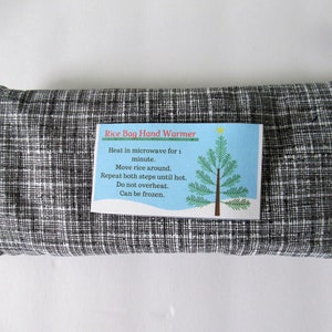 May include: A black and white checkered rice bag hand warmer with a blue and white label that reads "Rice Bag Hand Warmer" and includes instructions for heating and using the bag. The label also features a green Christmas tree with a yellow star.