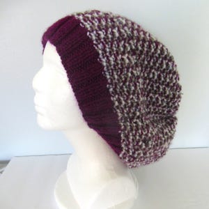 May include: A knitted beanie with a burgundy band and a white and brown speckled pattern.