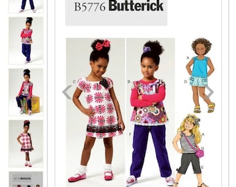 以下が含まれることがあります： 女の子向けのデザインが特徴のButterick B5776の縫製パターン。画像には、花柄や模様のデザインのドレス、トップス、パンツなど、さまざまな衣装が写っています。これらの衣装は若い女の子がモデルになっています。