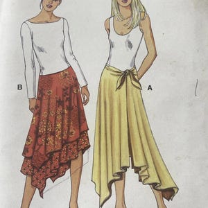 May include: Illustration of two women modeling different skirt and top combinations. One woman wears a white long-sleeve top with a red and orange floral skirt. The other wears a white tank top with a yellow skirt.