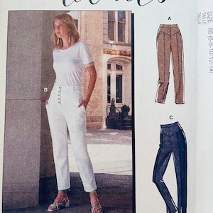 May include: A sewing pattern for pants with multiple views. The pattern includes instructions for making brown, white, and blue pants. The pattern is for sizes 6-8-10-12-14. The pattern is from McCall's and is called #AbbieMcCalls.