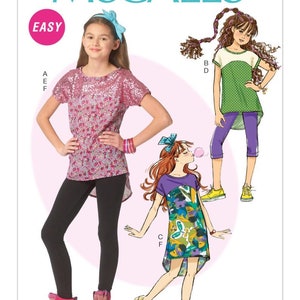 May include: McCall's sewing pattern for girls' clothing. The image shows a girl wearing a pink sequined top and black leggings. Illustrations depict other outfit options, including a green top with purple capri pants and a dress with a colorful floral design. The word "EASY" is visible.