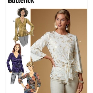 May include: A sewing pattern titled "B6628 Butterick" features illustrations of wrap-style tops. One top is white with gold accents and a tie front. Other tops are shown in purple, floral, and gold fabrics. The pattern includes long and three-quarter sleeves.