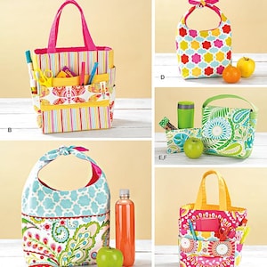 May include: A collection of colorful tote bags and lunch bags with various patterns, including floral, geometric, and striped designs. Some bags have exterior pockets and handles. The image also includes apples and a bottle of juice.