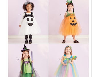 以下が含まれることがあります： Simplicityのコスチュームパターン。ハロウィーンのコスチュームを着た4人の子供たちがいます。コスチュームには、幽霊、カボチャ、魔女、そしてロリポップのカラフルなドレスが含まれています。パターンは米国で設計および印刷されています。