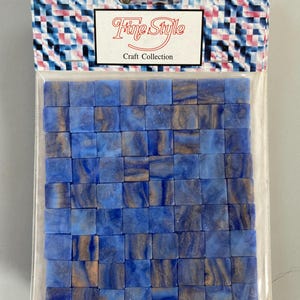 May include: A package of blue and gold mosaic tiles. The tiles are small, square, and have a marbled effect. The package is labeled "Fine Style Craft Collection".
