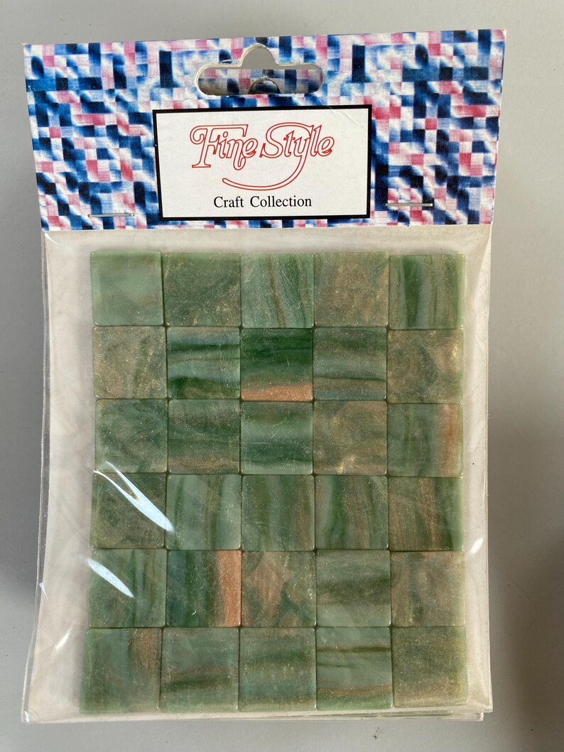 May include: A package of 36 green and brown mosaic tiles. The tiles are square and have a marbled look. The package is labeled "Fine Style Craft Collection".