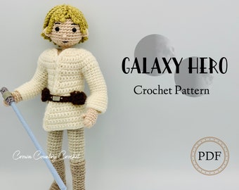 May include: Crochet pattern for a galaxy hero, a crocheted doll with a lightsaber. The pattern is available as a PDF download. The image shows a crocheted doll with a lightsaber, a white shirt, brown pants, and a brown belt. The doll has blonde hair and a brown face.