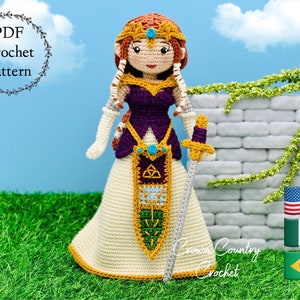 May include: Crochet pattern PDF for a princess doll with a purple dress, gold accents, and a sword. The doll has brown hair and blue eyes. The pattern is available in English, Spanish, Portuguese, and Japanese.