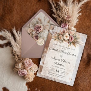 Op de afbeelding: Trouwuitnodigingsset met een mauvekleurige envelop en bloemmotief, een bijpassende uitnodigingskaart en droogbloemen. De uitnodigingstekst luidt: "Amelia Rose Carter & James Holden Walker trouwen op 14 september 2026."