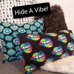 May include: Three decorative throw pillows with different patterns. The first pillow has a white background with black polka dots. The second pillow has a black background with a teal and blue geometric pattern. The third pillow has a black background with a rainbow colored lips pattern. The text "Hide A Vibe!" is visible in the image.