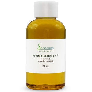 May include: A clear glass bottle with a white cap filled with toasted sesame oil. The label reads "soapeaty pure & natural toasted sesame oil unrefined expeller pressed 2 fl oz".