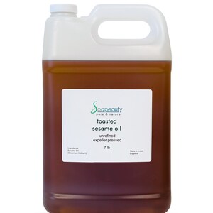 May include: A white plastic gallon jug filled with toasted sesame oil. The label reads "Soapeauty pure & natural toasted sesame oil unrefined expeller pressed 7 lb. Stone in a cool, dry place."
