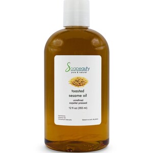 May include: A clear glass bottle with a white cap filled with toasted sesame oil. The label reads "Soapeauty pure & natural toasted sesame oil unrefined expeller pressed 12 fl oz (355 ml) Ingredients: Sesame Oil (Sesamum Indicum) Store in a cool dry place"