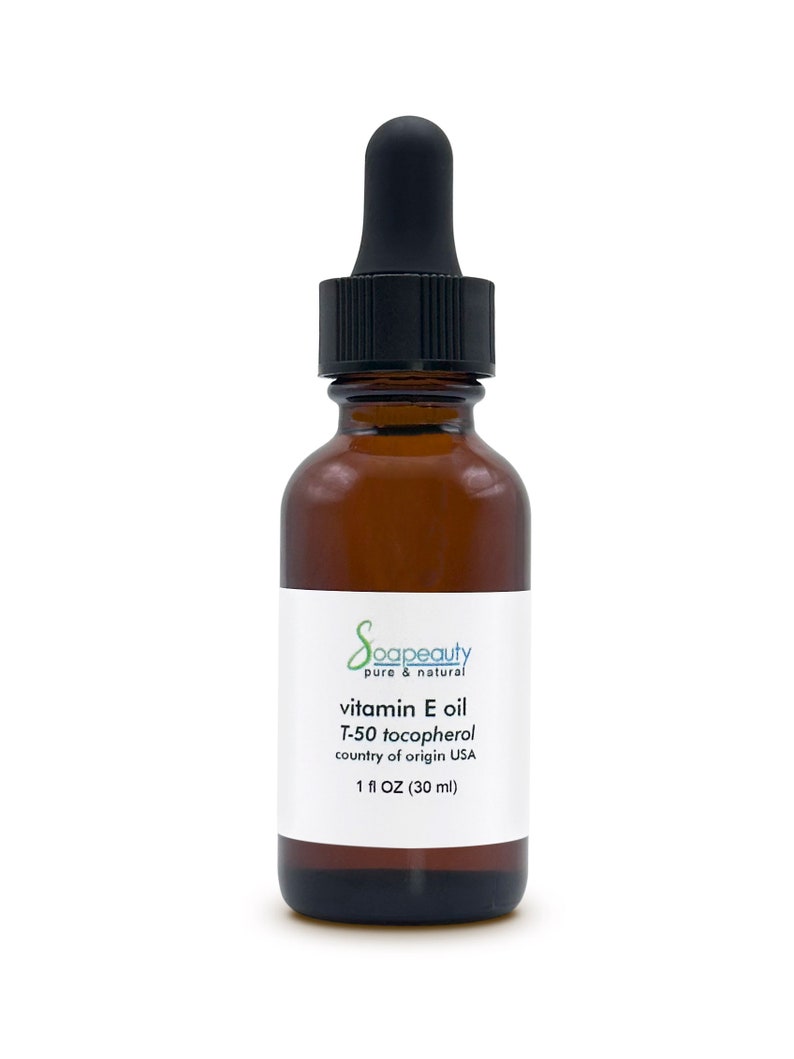 May include: A brown glass bottle with a black dropper top, labeled "Soapeauty pure & natural vitamin E oil T-50 tocopherol country of origin USA 1 fl OZ (30 ml)"