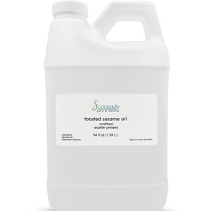 May include: A white plastic gallon jug of toasted sesame oil. The label reads "Scapeauty pure & natural toasted sesame oil unrefined expeller pressed 64 fl oz (1.89 L) Ingredients: Sesame Oil (Sesamum Indicum) Store in a cool, dry place."