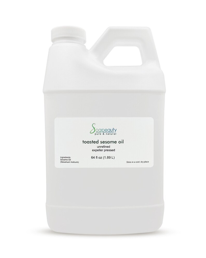 May include: A white plastic gallon jug of toasted sesame oil. The label reads "Scapeauty pure & natural toasted sesame oil unrefined expeller pressed 64 fl oz (1.89 L) Ingredients: Sesame Oil (Sesamum Indicum) Store in a cool, dry place."